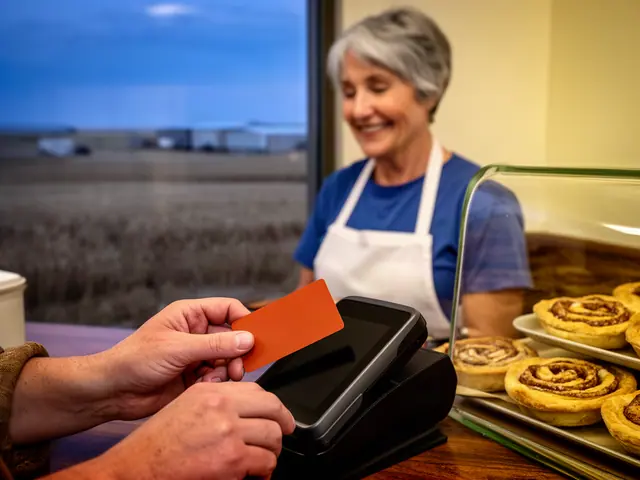 A customer taps a card on a counter terminal at a small diner counter.